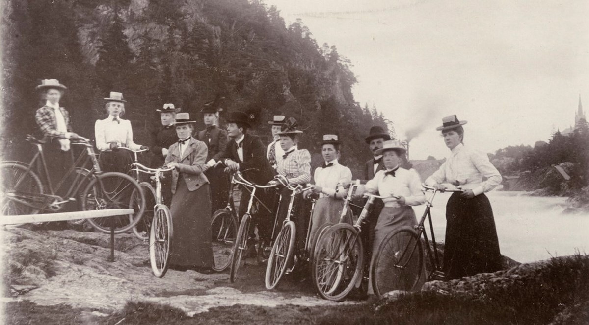 Ett svartvitt fotografi på en grupp kvinnor med cyklar på utflykt. Kort taget 1898. 